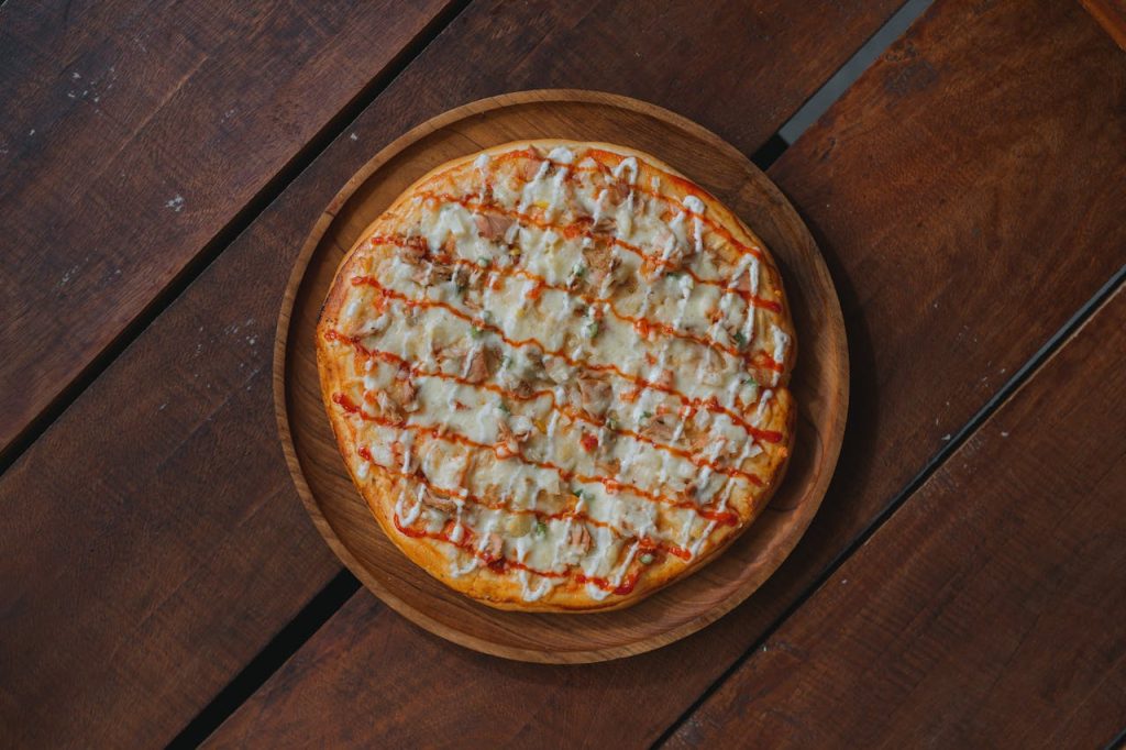 Mouth-watering homemade pizza topped with cheese on a rustic wooden table.