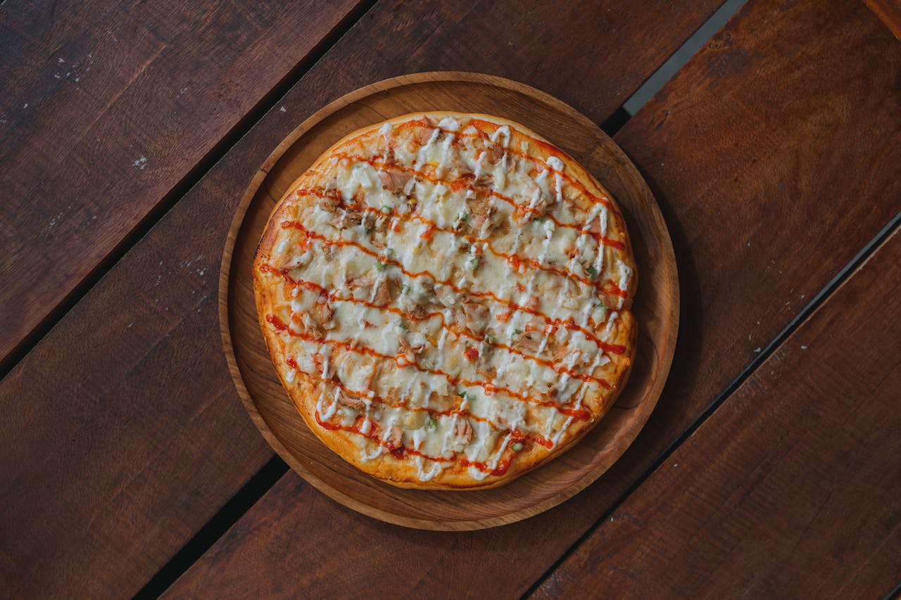 Mouth-watering homemade pizza topped with cheese on a rustic wooden table.